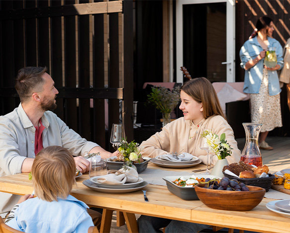 Family eating outdoors in outdoor living area.